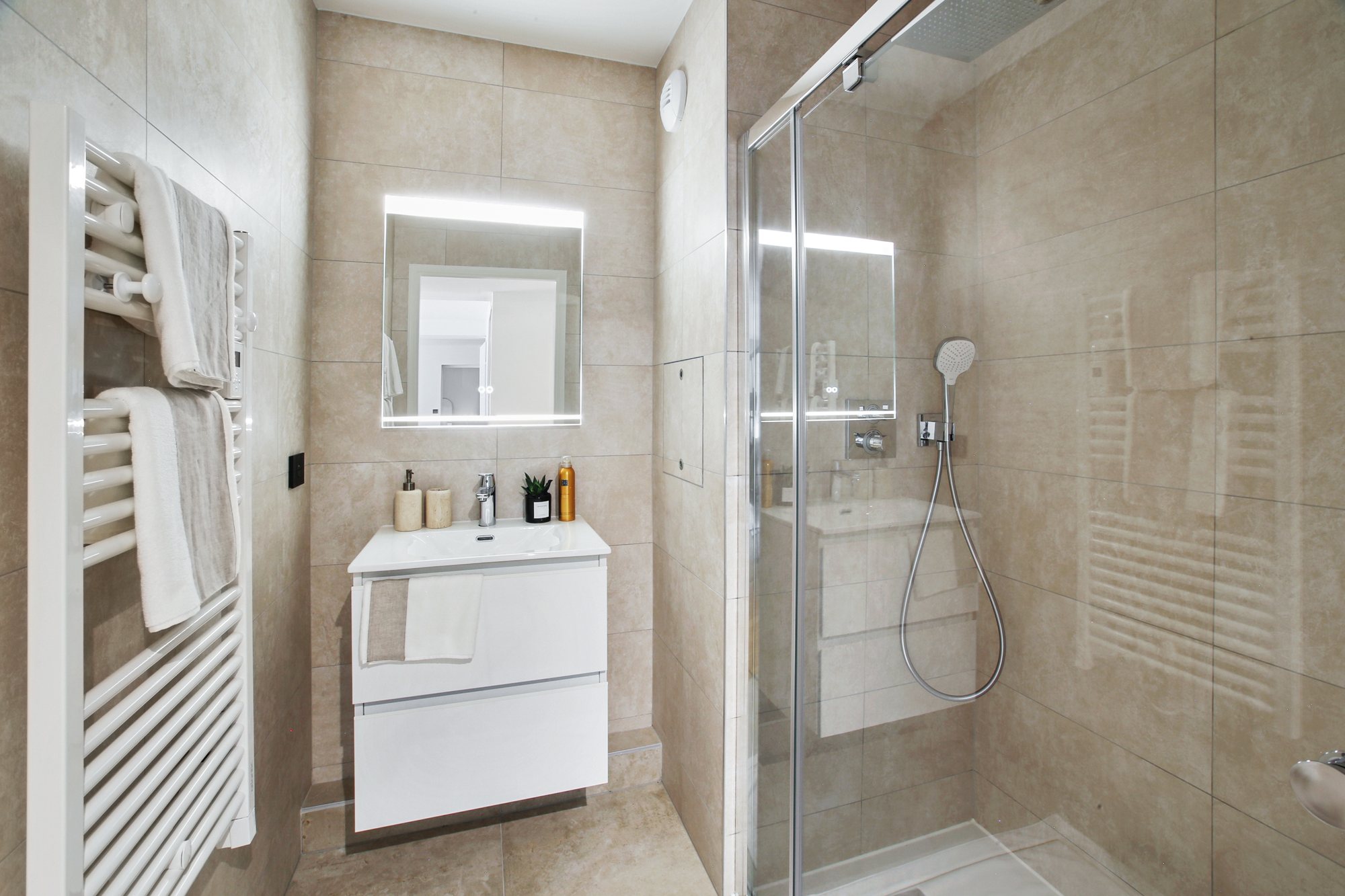 Salle de bains décorée avec douche vitrée et meuble vasque