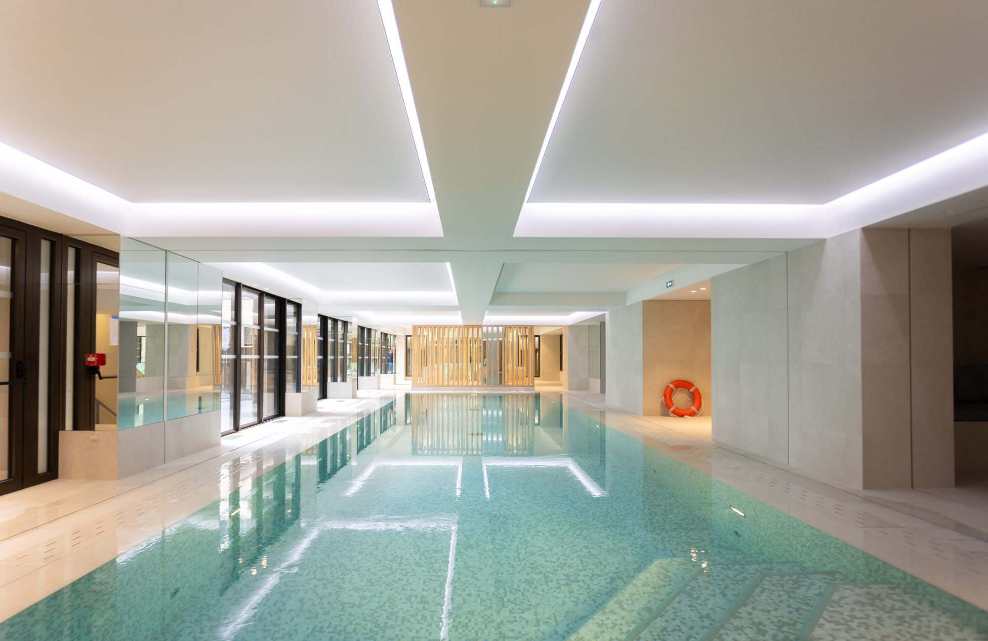 Piscine intérieure prolongée par les espaces communs