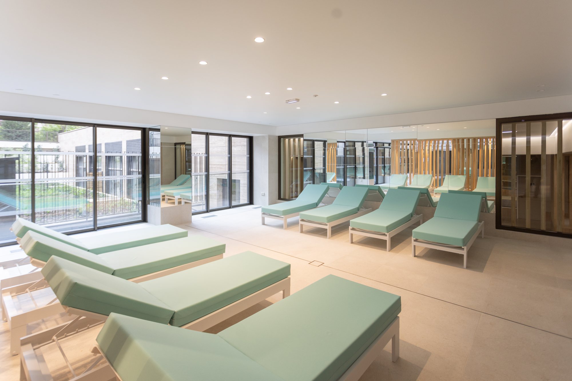 Espace piscine intérieur avec transats et lumière zénithale